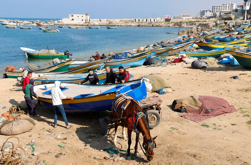 Сектор Газа. Местные жители перевозят рыбацкую лодку после ремонта в морском порту