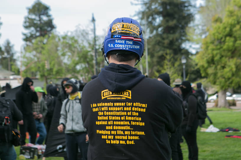 Участник движения стоит перед группой антифашистов во время митинга за свободу слова в Беркли
