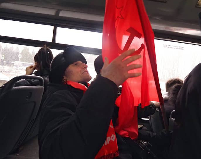 Участник церемонии с флагом СССР в салоне автобуса