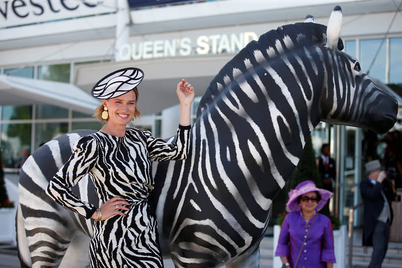 Эпсом, Великобритания. Женщина позирует рядом со статуей зебры на фестивале по скачкам Дерби