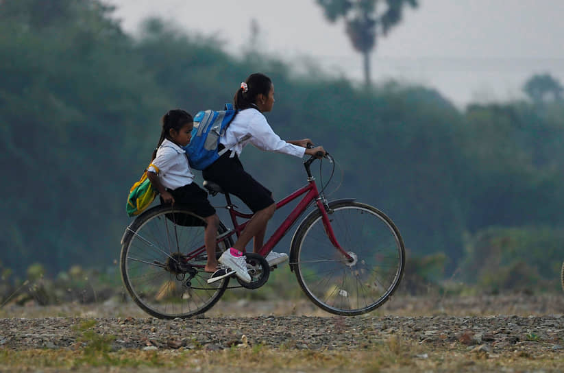 Пномпень, Камбоджа. Школьники едут в школу на велосипеде