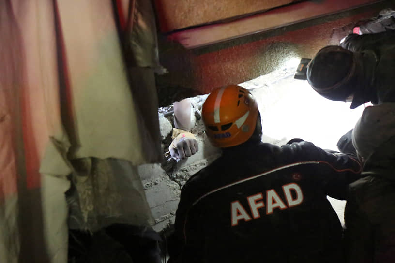 Спасатели пытаются вытащить человека, выжившего после обрушения дома в Диярбакыре (Турция)