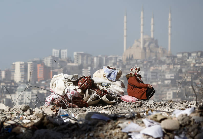 Кахраманмараш, Турция. Женщина сидит на развалинах своего дома 