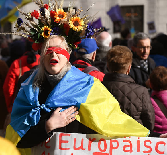 Женщина митингует в поддержку Украины во время проведения конференции