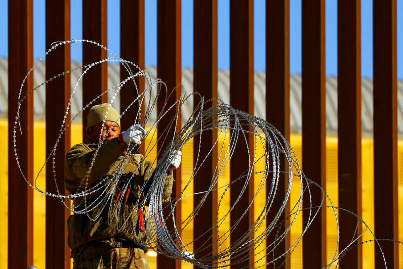 Военнослужащий Национальной гвардии США устанавливает колючую проволоку на американо-мексиканской границе в штате Техас