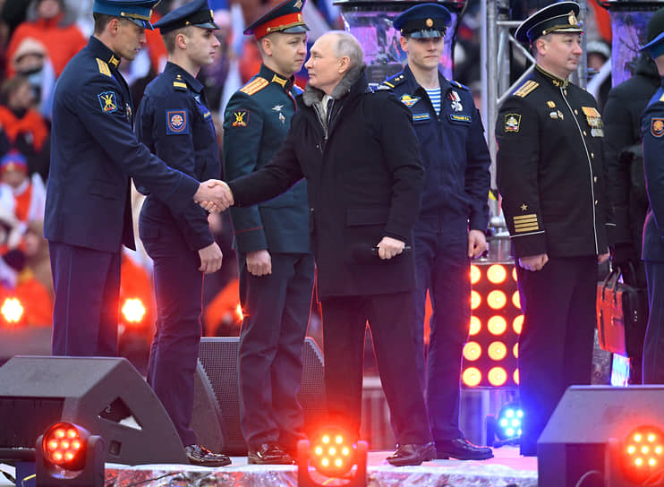 На сцену Владимир Путин поднялся вместе с участниками военной операции и пожал им руки