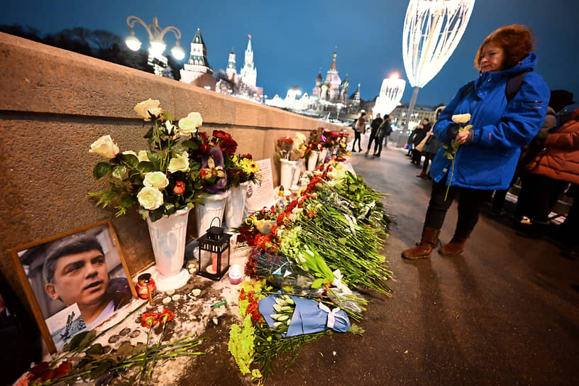 Женщина возлагает цветы на месте гибели политика-оппозиционера Бориса Немцова