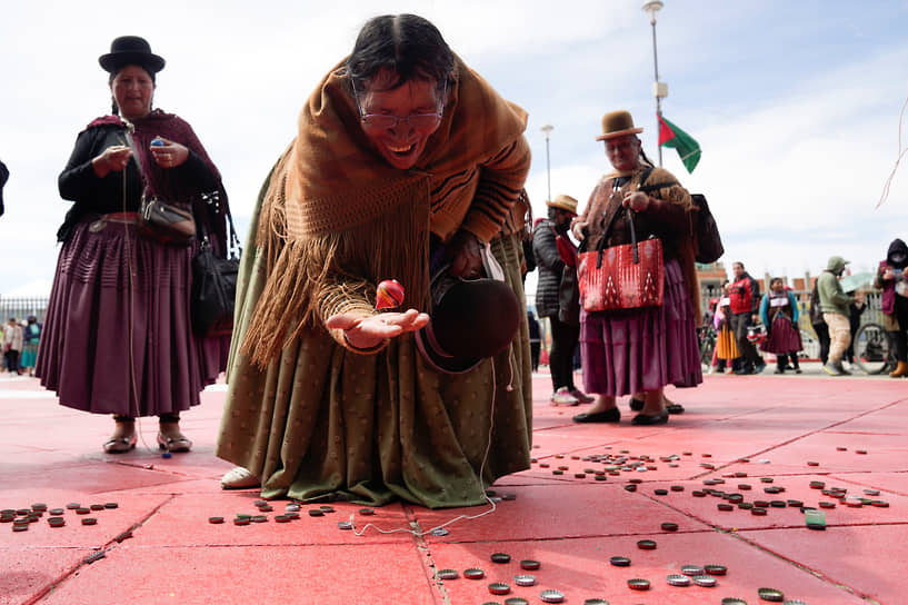 Эль-Альто, Боливия. Представительница народа аймара играет с волчком на празднике, посвященном годовщине основания города 
