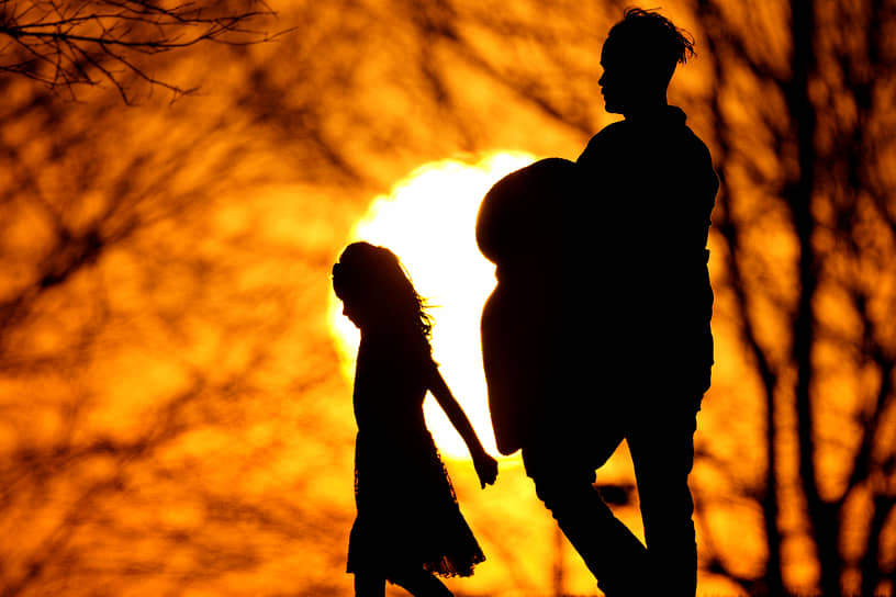 Канзас-Сити, США. Семья гуляет на закате в парке