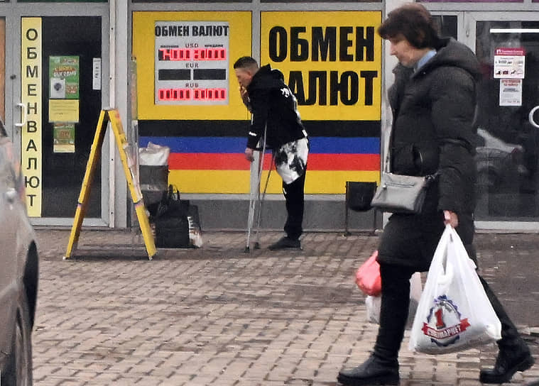 Мужчина на костылях возле пункта обмена валют в Донецке