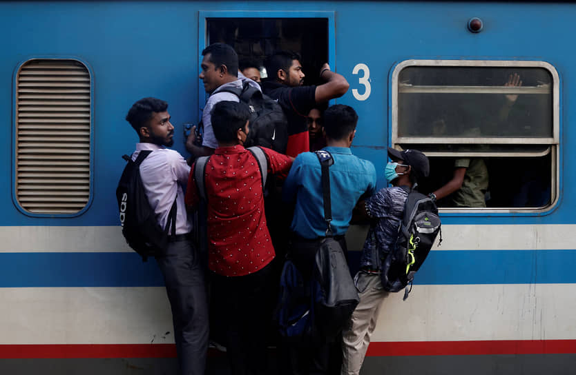 Коломбо, Шри-Ланка. Пассажиры едут на подножке поезда