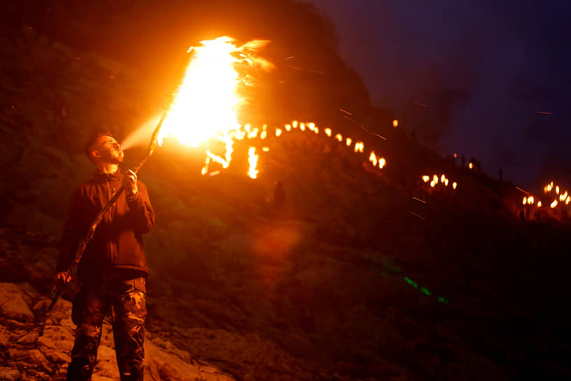 Мужчина разжигает факел в Акре (Ирак)
