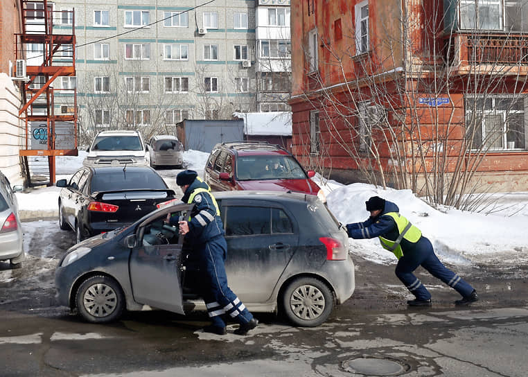 Омск. Сотрудники ДПС толкают автомобиль при выезде из двора 
