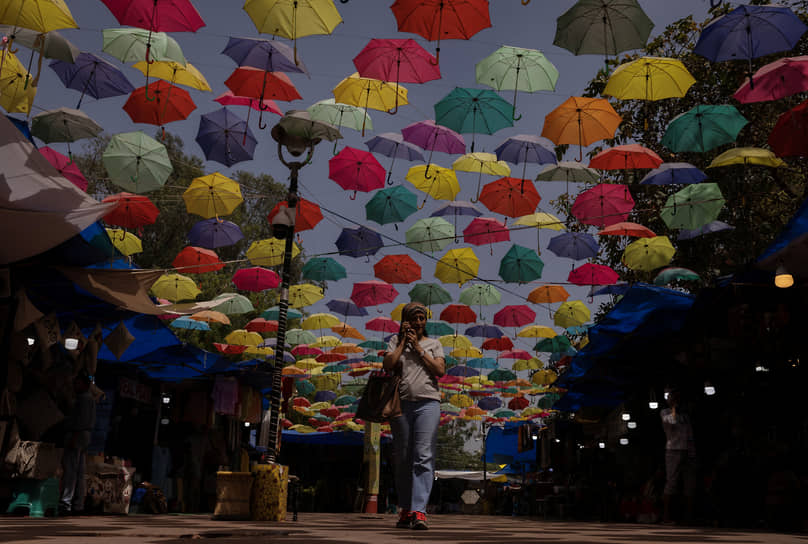 Нью-Дели, Индия. Местная жительница разговаривает по телефону, прогуливаясь по рынку 