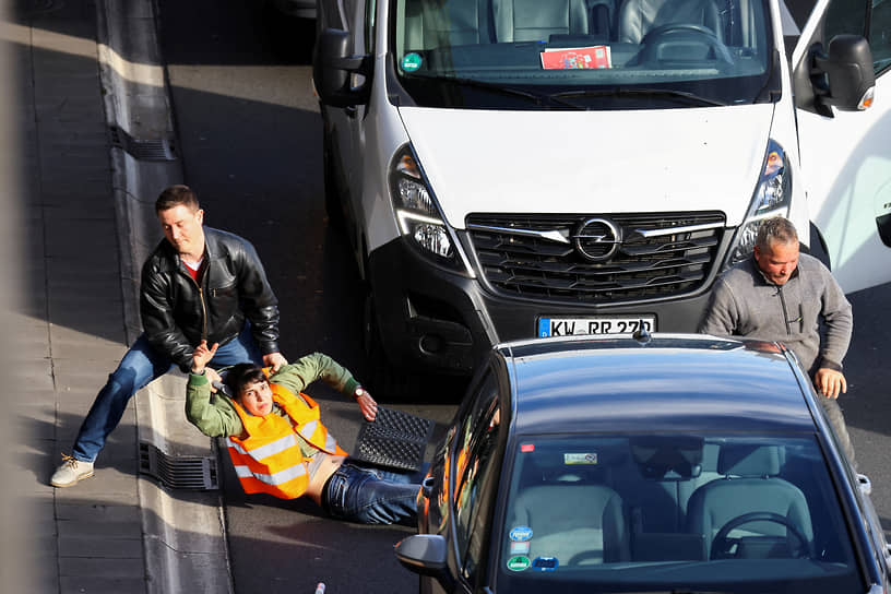 Берлин, Германия. Автомобилист оттаскивает активиста экологического движения «Последнее поколение», попытавшегося перекрыть трассу