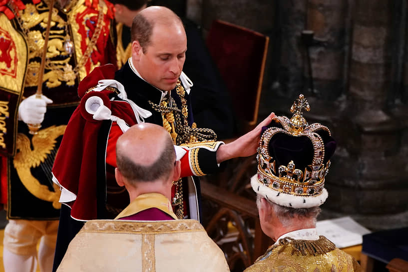 Британский принц Уильям прикасается к короне Святого Эдуарда на голове короля Карла III