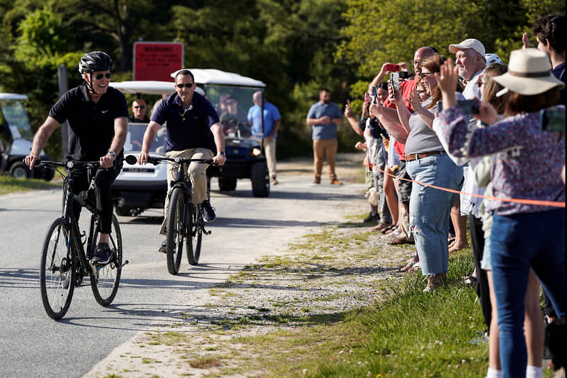 Рехобот-Бич, США. Местные жители фотографируют американского президента Джо Байден во время велопрогулки