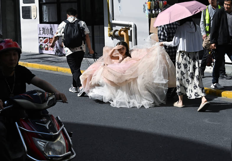 Шанхай, Китай. Девушку в свадебном платье везут на фотосессию по улицам города
