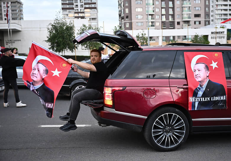 Мужчина с флагом и портретом действующего президента Турции Реджепа Тайипа Эрдогана на автомобиле