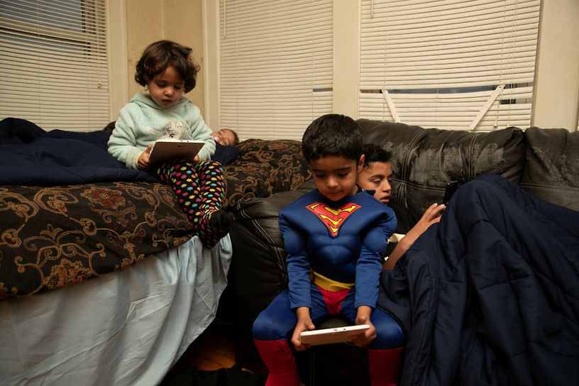 Боулинг Грин, США. Дети играют в планшеты в пункте временного размещения для афганских беженцев, 2021 год