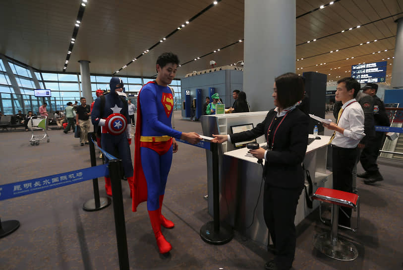 Куньмин, Китай. Член экипажа авиакомпании Lucky Air проходит контроль в костюме Супермена для празднования Хэллоуина на борту самолета, 2014 год