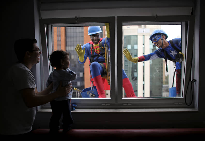 Сан-Паулу, Бразилия. Мойщики окон в костюмах супергероев приветствуют пациента детской больницы и его отца, 2013 год