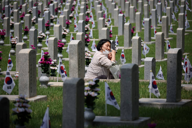 Сеул. В преддверии Дня памяти женщина сидит у могилы родственника, погибшего в Корейской войне