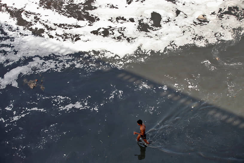 Ахмедабад, Индия. Местный житель ищет вторсырье в загрязненных водах реки Сабармати