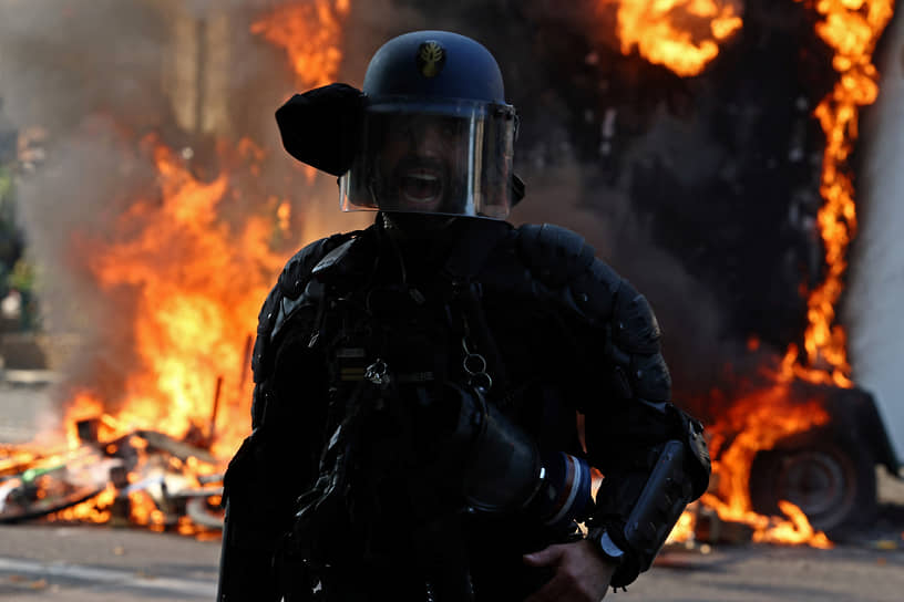 Французский жандарм на фоне горящего трейлера