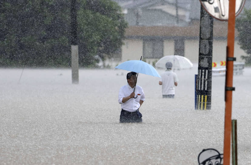 Куруме, Япония. Местные жители идут по затопленной ливнями улице