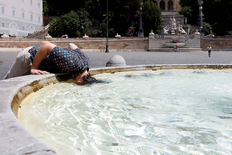 Рим. Мужчина освежается в фонтане на площади Пьяцца-дель-Пополо
