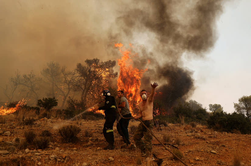 Афины, Греция. Местные жители помогают пожарным тушить горящий лес 