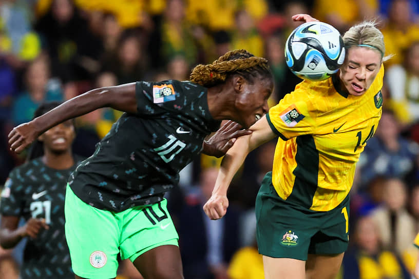 Австралийская футболистка Аланна Кеннеди (справа) принимает головой мяч в матче против Нигерии