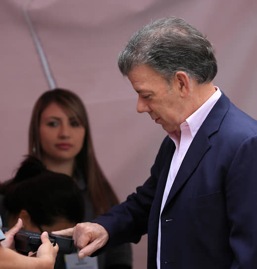 Президент Колумбии Хуан Мануэль Сантос проходит проверку по отпечаткам пальцев перед тем, как принять участие в голосовании на выборах, 2014 год