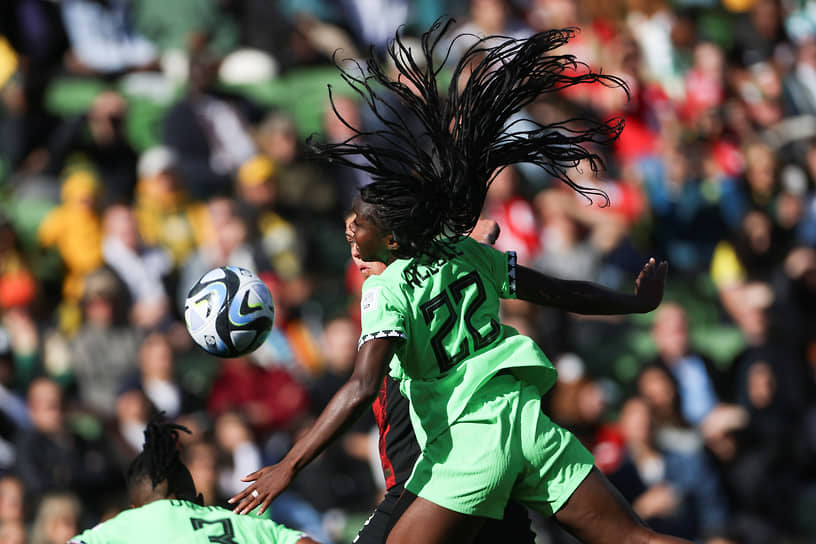Нигерийская футболистка Мишель Алози забивает мяч головой в матче с Канадой