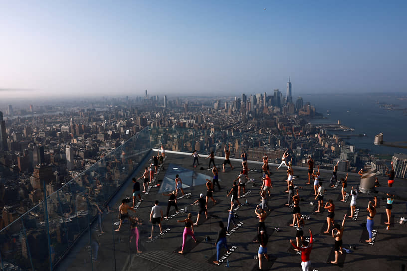 Нью-Йорк, США. Люди занимаются йогой на крыше небоскреба