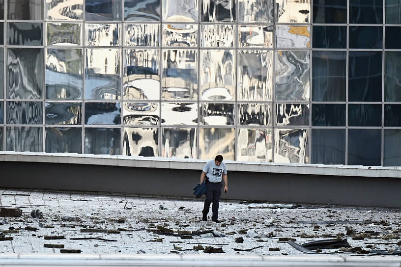 Москва. Мужчина осматривает обломки фасада после атаки беспилотника на «Москва-Сити»