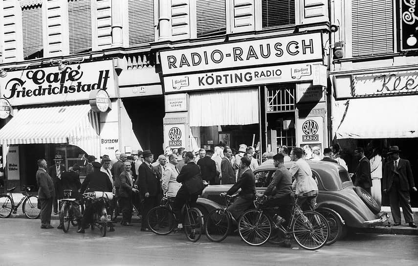 Берлинцы слушают последние новости, передаваемые через громковорители на улицах города в августе 1939 года