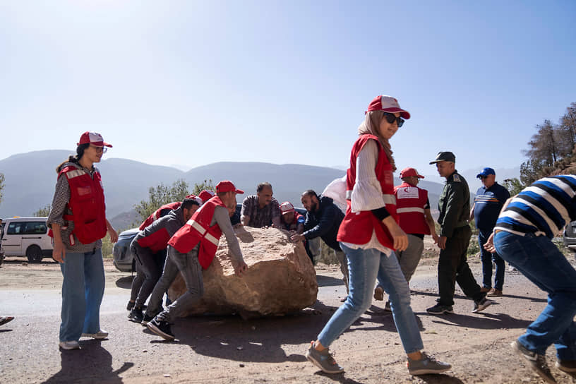 Марокканские спасатели убирают камни, упавшие на дорогу во время землетрясения