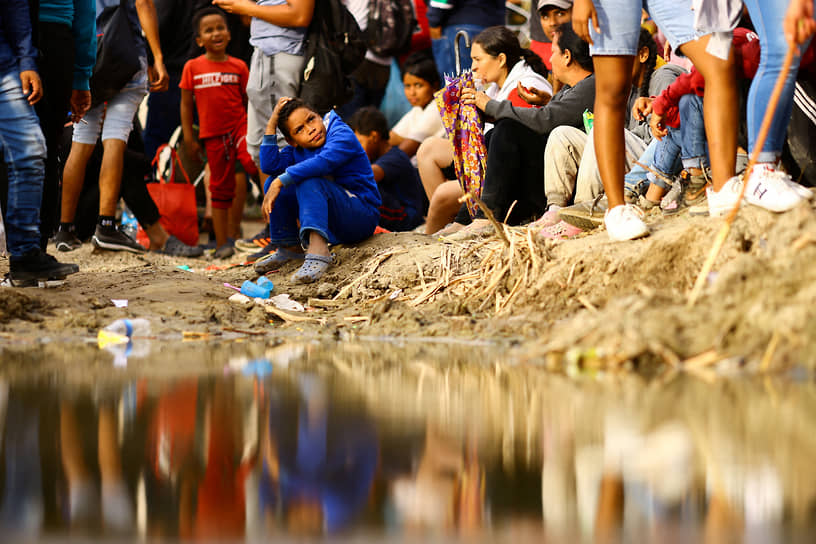 Сьюдад-Хуарес, Мексика. Ищущие в США убежище мигранты собрались возле проволочного забора на берегу реки Рио-Браво