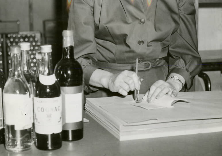 Женщина ставит штамп в мотбук — шведскую книгу учета потребления алкоголя, 1955 год