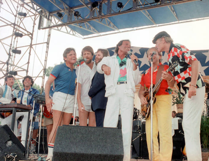Музыкальную карьеру Хулио Иглесиас начинал с выступлений в пабах Лондона, куда переехал ради учебы. Вернувшись на родину, в 1968 году молодой человек выиграл испанский конкурс талантов «Песня-68». После этого он подписал контракт с звукозаписывающей студией Discos Columbia — местным филиалом американской компании Columbia Records&lt;br>На фото: певец (третий слева) с участниками группы Beach Boys на концерте в Вашингтоне