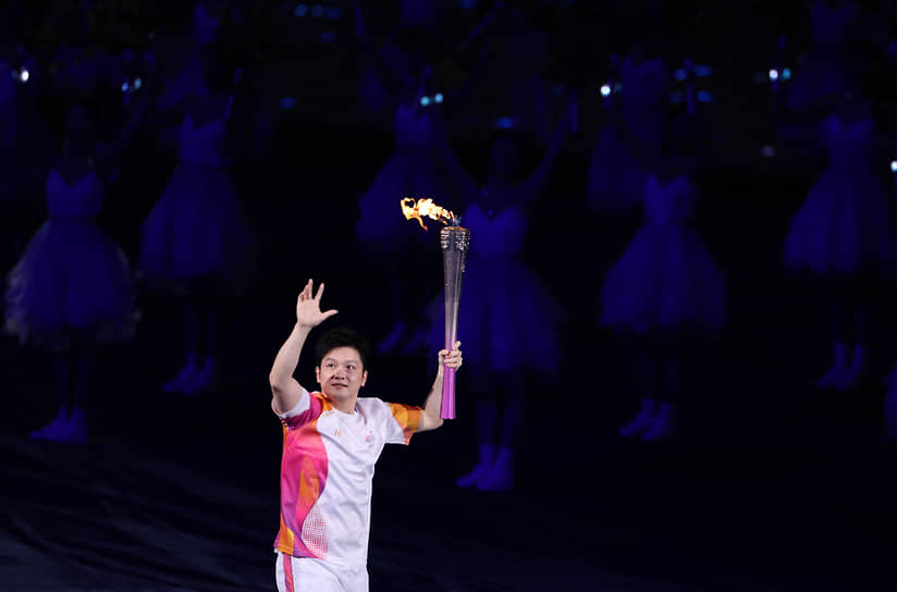 Китайский игрок в настольный теннис Фань Чжэндун несет факел на церемонии открытия