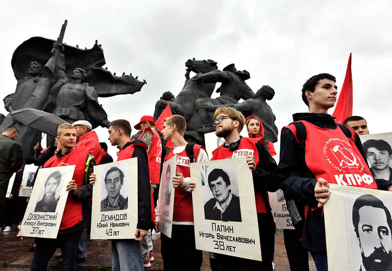Участники акции держат портреты жертв расстрела Дома советов