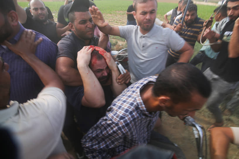 Палестинцы перевозят захваченного израильского мирного жителя (в центре) из кибуца Кфар-Аза в сектор Газа