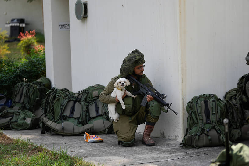 Израильский солдат с собакой во время перестрелки в кибуце Кфар-Азза 