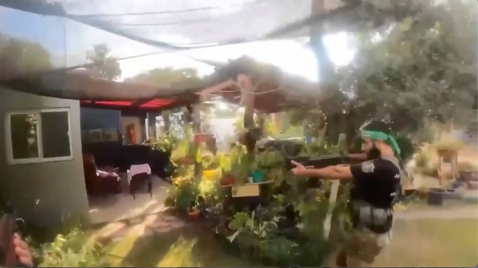 На снимке, сделанном с камеры видеонаблюдения, — боевик «Хамаса» расстреливает дом на юге Израиля