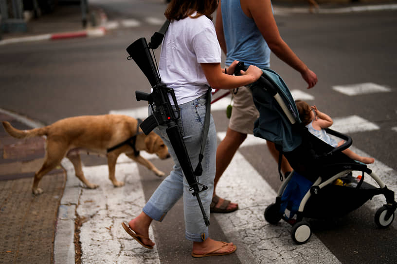 Израильский военный во время прогулки со своей племянницей в центре Тель-Авива (Израиль)