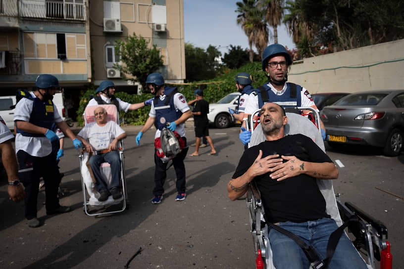 Медики эвакуируют раненых из поврежденного здания в Тель-Авиве (Израиль)