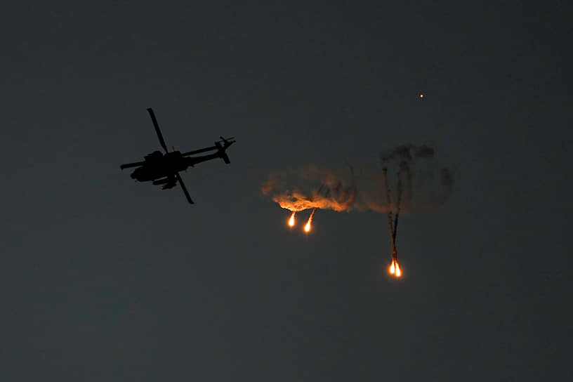 Израильский вертолет «Апач» запускает осветительные ракеты над сектором Газа
